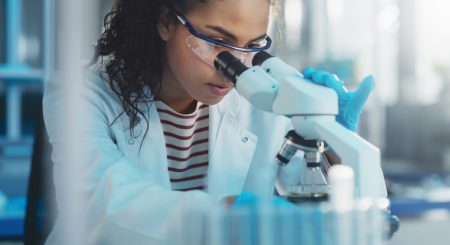 Medical Science Laboratory: Portrait of Beautiful Black Scientist Looking Under Microscope Does Analysis of Test Sample. Ambitious Young Biotechnology Specialist, working with Advanced Equipment